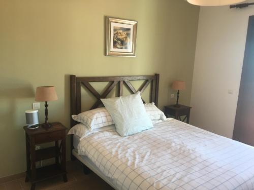 卡萨雷斯Casares Village Bed & Breakfast的一间卧室配有一张带2个床头柜和2盏灯的床。