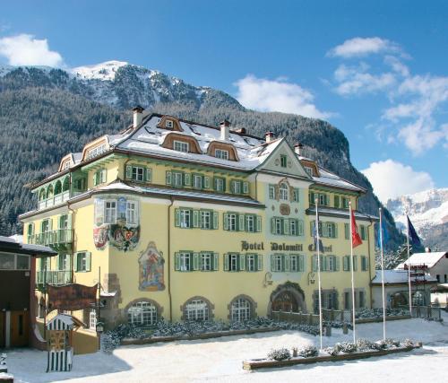 卡纳泽伊Hotel Dolomiti Schloss的山前的黄色大建筑