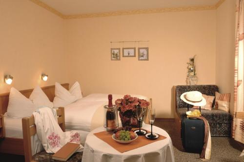 布兰德Landhaus-Pension Zum Waffenschmied的配有床和鲜花桌的酒店客房