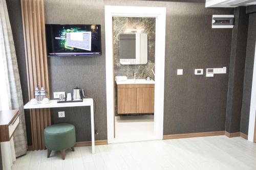 伯萨KAR BEYAZ HOTEL BURSA的一间带水槽的浴室和墙上的电视