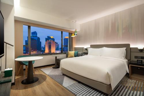 上海上海南京路步行街假日酒店的酒店客房设有一张床和一个大窗户