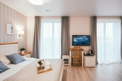 维尔纽斯Real House Jasinskio SMART-APP SELF CHECK-IN的酒店客房,配有床和鲜花桌