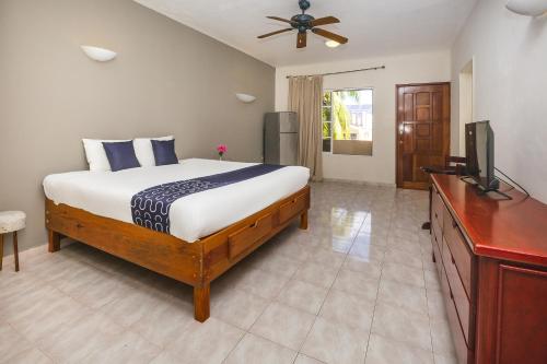 科苏梅尔Hotel Kiin Cozumel的一间卧室配有一张床和一台平面电视