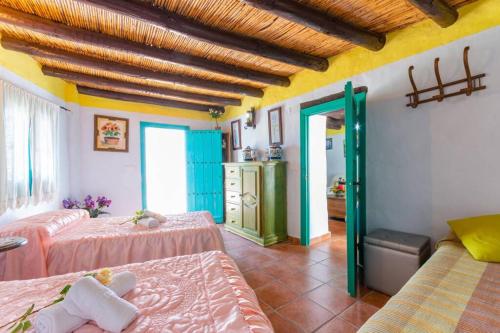 弗里希利亚纳Casa Rosa, con encanto y piscina climatizada的一间带两张床的卧室和一间带浴室的房间