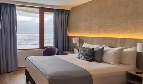 金特罗Yachting Hotel Quintero的酒店客房,设有一张床铺,享有海景