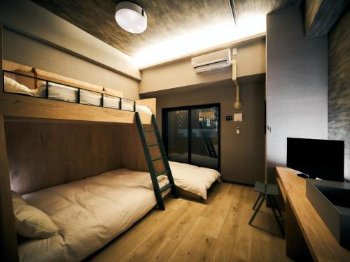 福冈Rakuten STAY Fukuoka Yakuin Bunk bed Triple Room的客房设有两张双层床和一张书桌。