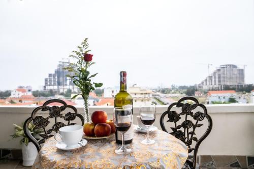 洞海Rose Hotel Quảng Bình的一张桌子,上面放着一瓶葡萄酒和两杯酒