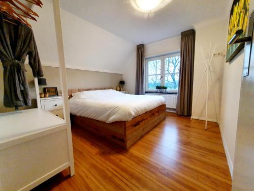 Sint-OedenrodeB & B de Stok的一间卧室配有一张床,铺有木地板