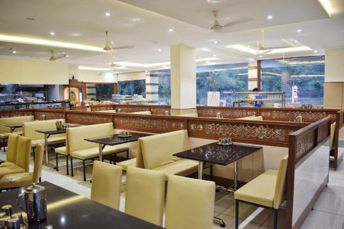 SubrahmanyaBhramari Nest的一间带桌椅的餐厅和一间酒吧