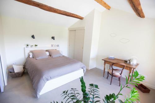 ReyrieuxLe Relais de la Godasse的一间卧室配有一张床和一张木桌