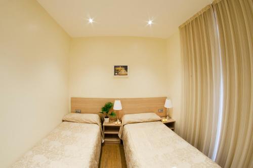巴塞罗那卓越旅馆的客房设有两张床和窗户。