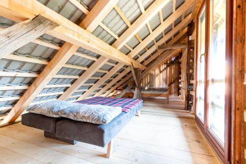 TrebnjeGlamping - Hayrack Vesel的配有木制天花板和窗户的客房内的一张床位