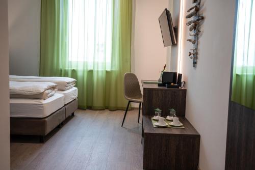 Neupirkaeee Hotel Graz的一间卧室配有一张床和一张桌子及椅子