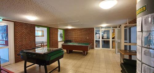 费马恩Jugendherberge Fehmarn的配有乒乓球桌和台球桌的房间
