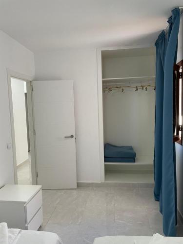 罗萨里奥港Apartamentos Tamasite的白色的客房配有一张床和一个衣柜