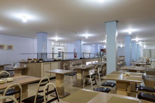 伊瓜苏巴维拉伊瓜苏酒店的一间带桌椅的餐厅和一间厨房