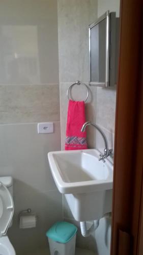 卡博迪圣阿戈斯蒂尼奥Kitnet 1,Vista fantastica的浴室设有白色水槽和粉红色毛巾。