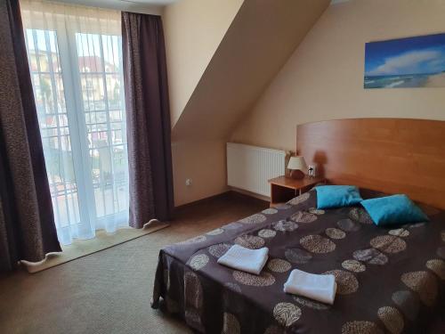 米兹多洛杰Amberek Dom Gościnny的一间卧室设有一张大床和一个大窗户