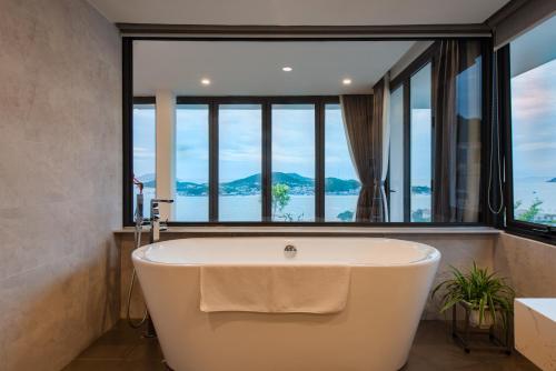 芽庄Casa Blanca Villas的带浴缸的浴室和大窗户