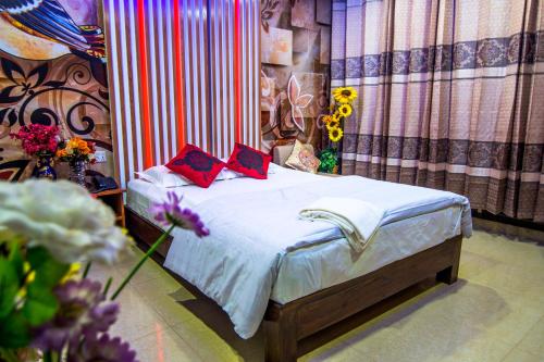 KhulnaHotel Pushpo Bilash的一间卧室配有一张带两个红色枕头的床