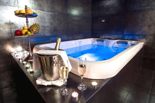 扎博克Hotel & Restoran Dvorac Gjalski的浴缸配有酒杯和一瓶香槟