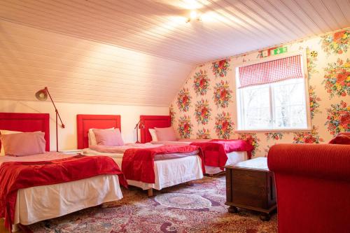 韦斯特罗斯Hem till Gården boutique hotel的一间卧室设有三张床和窗户。