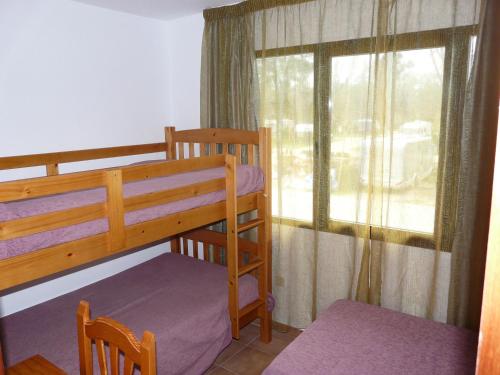 阿兰约兹Aranjuez Camping & Bungalows的一间卧室设有两张双层床和一扇窗户。