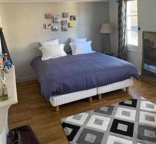 翁弗勒尔Chambre d’hôtes du Carré des Arts的一间卧室配有一张带蓝色床单和白色枕头的床。
