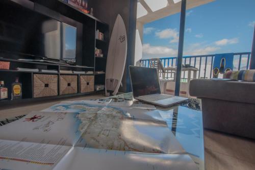 法马拉Casa Paradiso with great views perfect for surf or family holidays的客厅桌子上放置的笔记本电脑