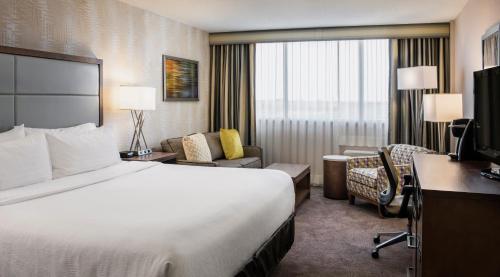 温尼伯温尼伯南假日酒店的配有一张床和一张书桌的酒店客房