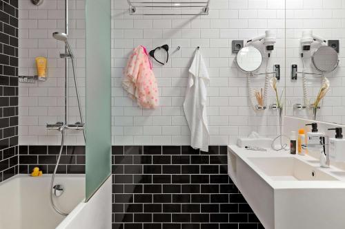 赫尔辛基斯堪迪克帕西酒店的浴室配有水槽、淋浴和浴缸。