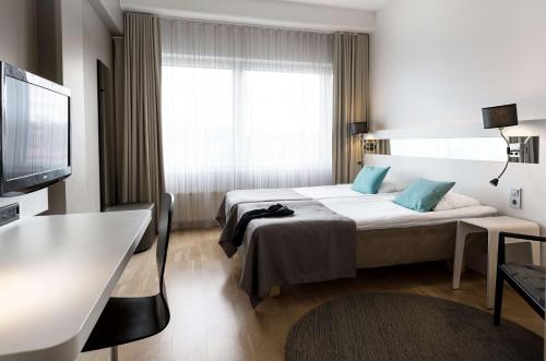 图尔库斯堪迪克朱莉娅酒店的配有一张床和一台平面电视的酒店客房