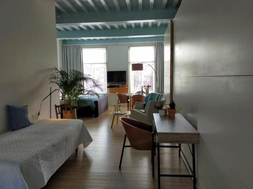 莱顿B&B Hart van Leiden的一间卧室配有一张床,客厅配有桌子