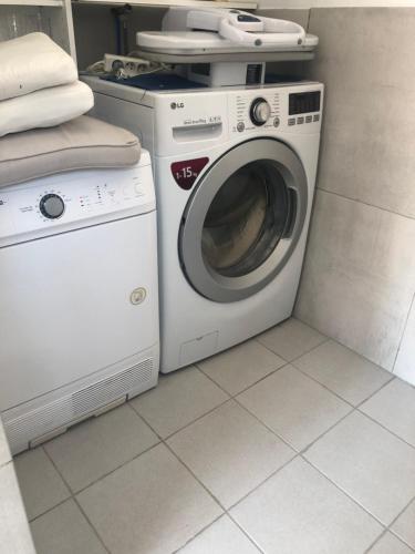 弗龙蒂尼昂FLAMANTS ROSES 2的客房内的洗衣机和洗衣机