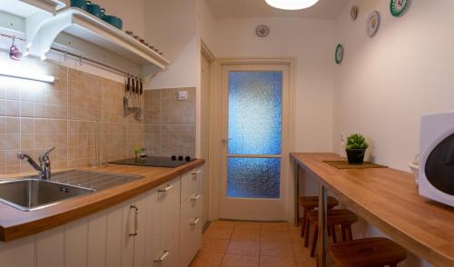 凯斯特海伊Helikon 32 Apartman Keszthely的厨房配有水槽和带窗户的台面