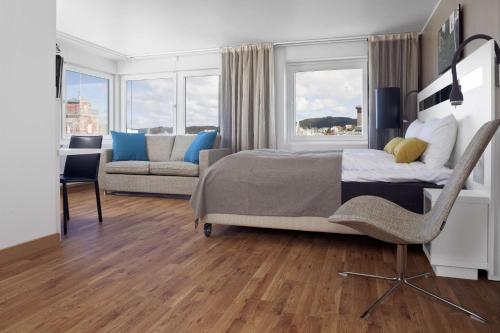 海宁格松斯堪迪克海于格松酒店的一间卧室配有一张床、一把椅子和一张沙发