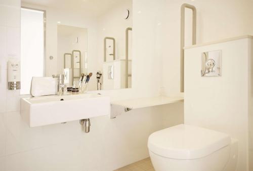 海宁格松斯堪迪克海于格松酒店的白色的浴室设有卫生间和水槽。