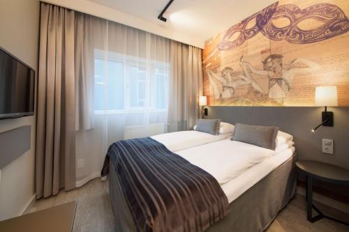 奥斯陆圣奥拉夫普拉斯斯堪迪克酒店的酒店客房设有一张床,墙上挂有绘画作品