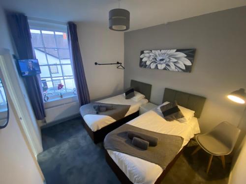 金顿The Swan Hotel的小房间设有两张床和窗户