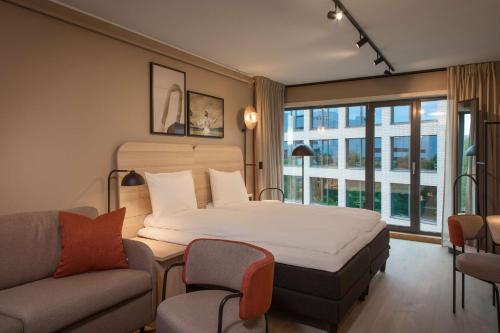 奥斯陆斯福尔斯堪迪克酒店的一间卧室配有一张大床、一张沙发和一张沙发。