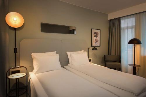 利勒哈默尔斯堪迪克维多利亚酒店的酒店客房,配有白色的床和椅子