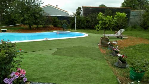 BeurlayLA PASTORALE的一个带游泳池和花草草坪的庭院