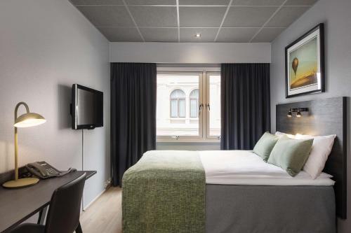 德拉门德拉门安巴萨多斯堪迪克酒店的配有一张床、一张书桌和一扇窗户的酒店客房