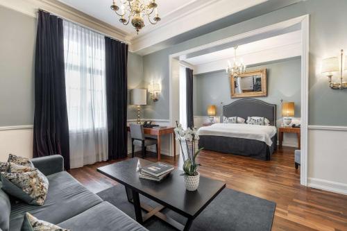 奥斯陆Grand Hotel Oslo的酒店客房配有一张床铺和一张桌子。