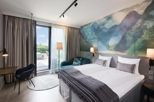 卑尔根斯堪迪克弗莱兰机场酒店的一间卧室设有一张大床和一个大窗户