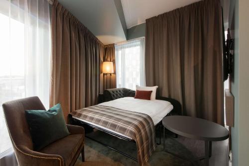 利勒斯特罗姆斯堪迪里尔斯特罗姆酒店的配有一张床和一把椅子的酒店客房