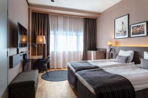 万塔赫尔辛基机场斯堪迪克酒店的酒店客房设有一张大床和一张书桌。