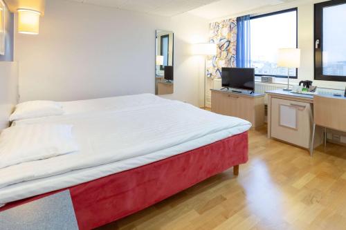 赫尔辛基哈卡尼米斯堪迪克酒店的一间卧室配有一张大床和一张带电脑的书桌