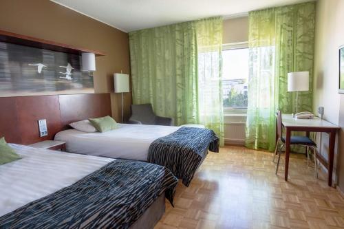 于韦斯屈莱于韦斯屈莱市斯甘迪克公寓的酒店客房设有两张床、一张书桌和一个窗户。