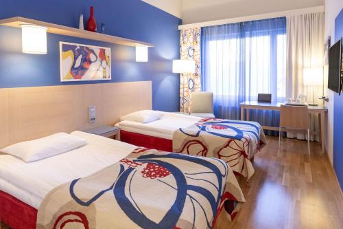 许温凯斯堪迪克赫维嘎酒店的两张位于酒店客房的床,拥有蓝色的墙壁